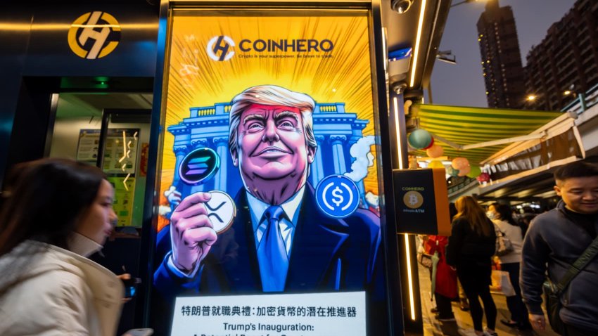 A cartoon image of US President-elect Donald Trump with cryptocurrency tokens, depicted in front of the White House to mark his inauguration, displayed at a Coinhero store in Hong Kong, China, on Monday, Jan. 20, 2025. 