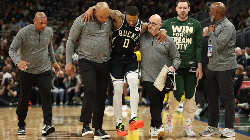 Damian Lillard of the Milwaukee Bucks is helped off the court