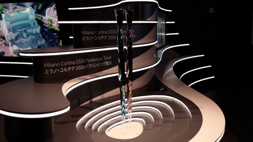 Torches for the Winter Olympics on display on a stage.