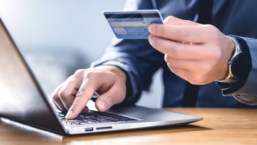 Safe online payment and electronic money transfer security. Pay with digital technology. Man using credit card and laptop to login to internet bank. Financial safety to prevent scam, threat and fraud.