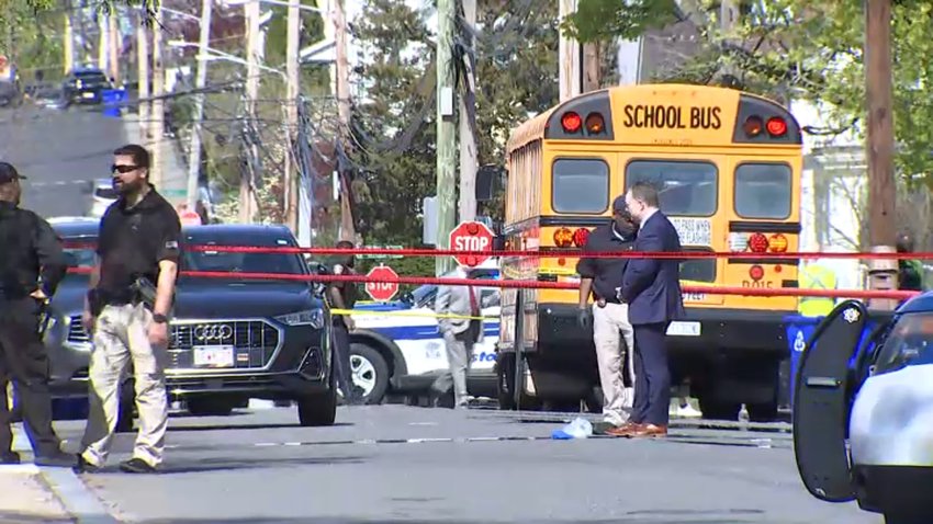First responders on scene after a pedestrian was struck by a school bus. The bus can be seen cordoned off by red police tape.