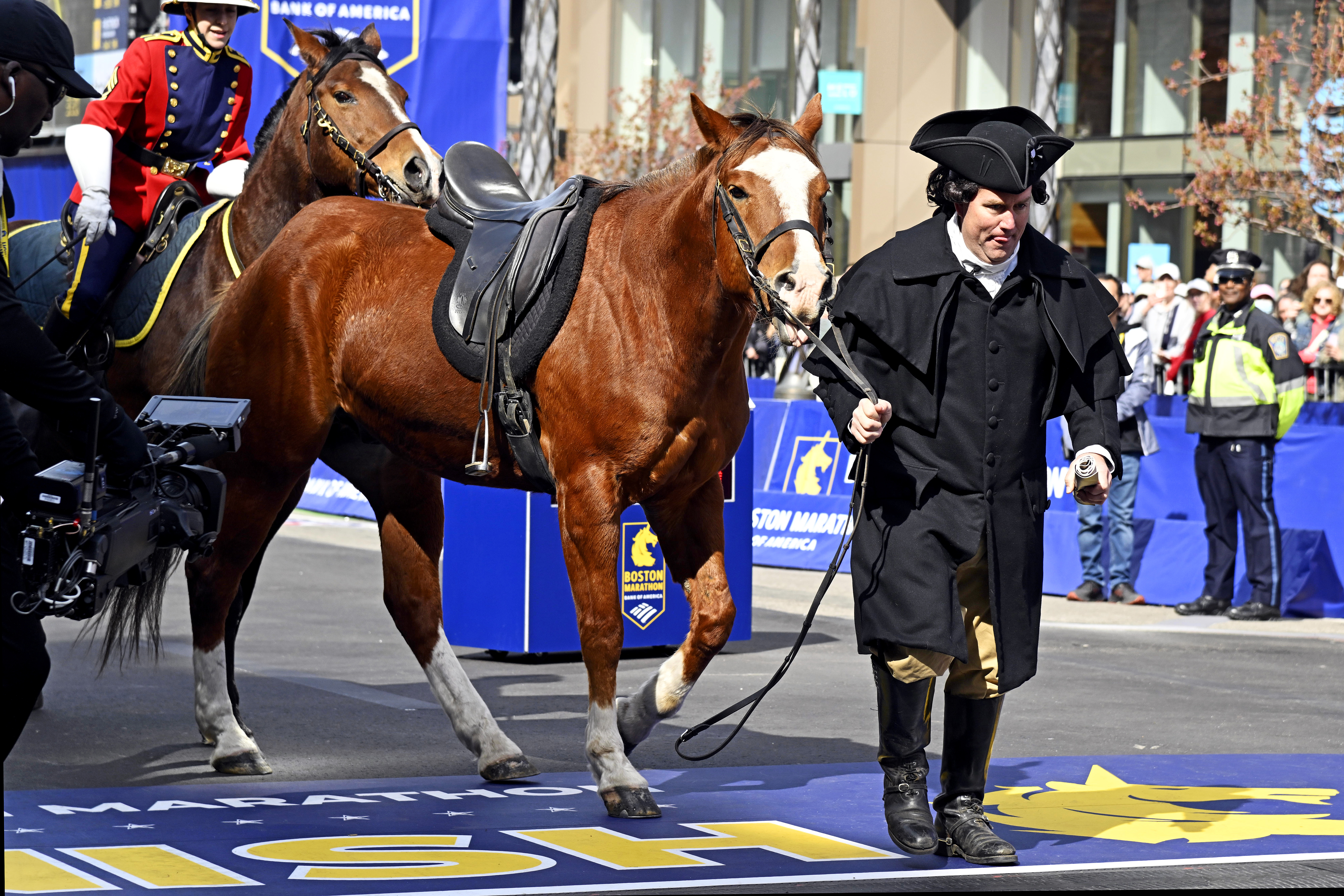 Apr 21, 2025; Boston, MA, USA; An actor portraying Paul Revere tries to pull his horse named “Law” across the finish line before the 2025 Boston Marathon. Mandatory Credit: Eric Canha-Imagn Images