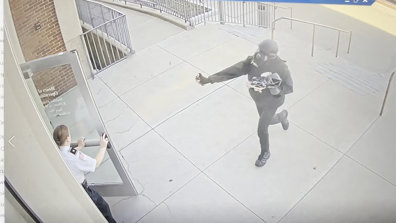 Surveillance footage shows a man in a helmet and gas mask pepper-spraying a court officer at Woburn District Court on Monday, April 14, 2025.