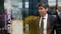 Sam Altman, CEO of OpenAI, is seen through glass during an event on the sidelines of the Artificial Intelligence Action Summit in Paris, Feb. 11, 2025.
