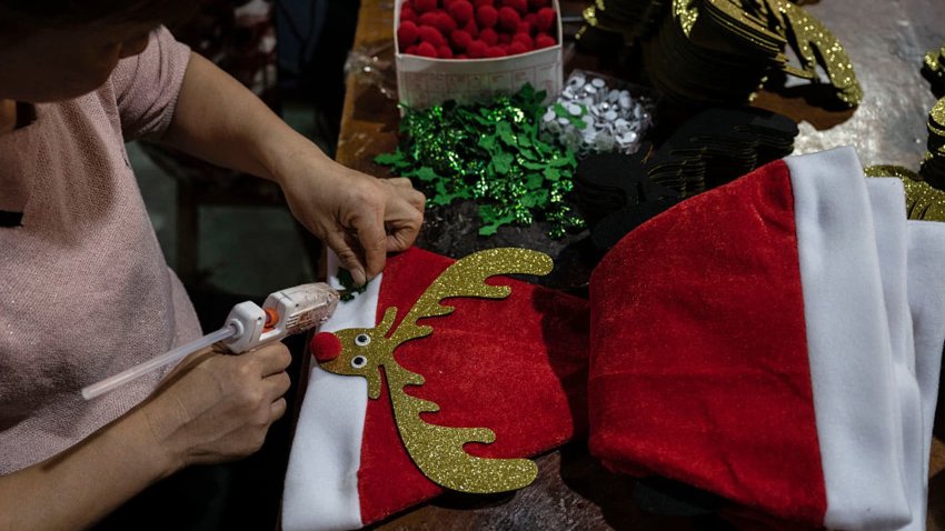 A worker finishes red Santa Claus hats for export at a factory on April 28, 2025, near Yiwu, Zhejiang province, China.
