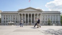 Pedestrians walk past the north entrance to the U.S. Treasury Department headquarters building on April 30, 2025, in Washington, DC.