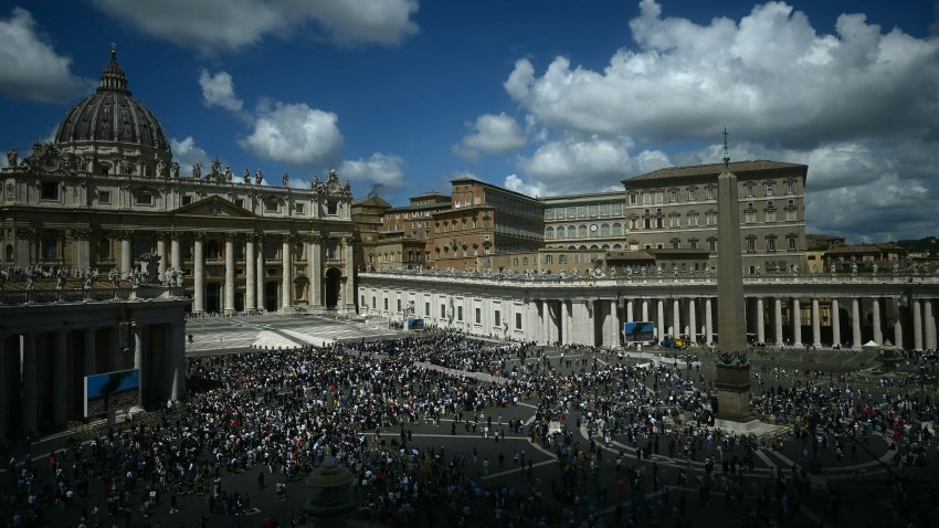 TOPSHOT – This photograph shows a general view of St Peter’s Square with St Peter’s Basilica (L) as black smoke rises from the chimney of the Sistine Chapel (C) signalling that cardinals failed to elect a new pope during their conclave in the Vatican on May 8, 2025. (Photo by Filippo MONTEFORTE / AFP) (Photo by FILIPPO MONTEFORTE/AFP via Getty Images)