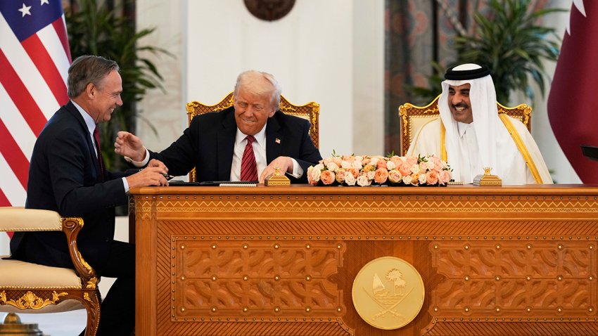 President Donald Trump, center, Qatar's Emir Sheikh Tamim bin Hamad Al Thani and Kelly Ortberg, President and Chief Executive Officer, The Boeing Company, left, share a moment during a signing ceremony at the Amiri Diwan in Doha, Qatar, Wednesday, May 14, 2025.