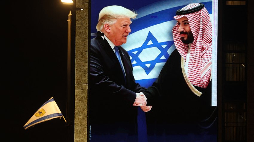 A billboard bearing a picture depicting President Donald Trump shaking hands with Saudi Crown Prince Mohammed bin Salman with the slogan above: "history won't wait" is displayed by the Coalition for Regional Security group on the facade of a hotel building in Jerusalem on May 12, 2025.