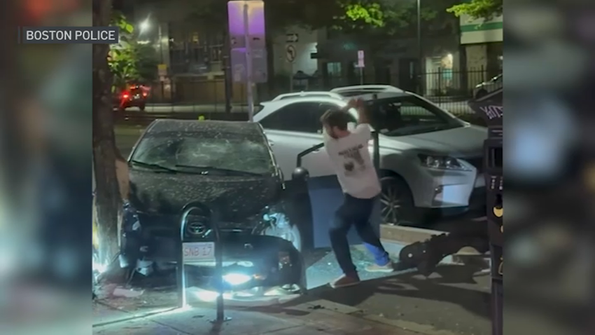 A man attacking a damaged car with what police have described as a hatchet in Boston's Brighton neighborhood on Friday, May 16, 2025.