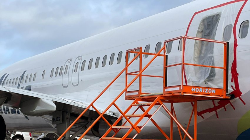 Plastic covers the exterior of the fuselage plug area of Alaska Airlines Flight 1282 Boeing 737-9 MAX