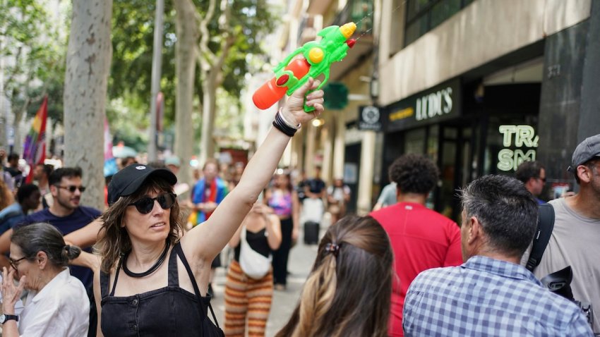 A protester with a water gun takes part in a protest against overtourism in Barcelona, Spain, Sunday, June 15, 2025.
