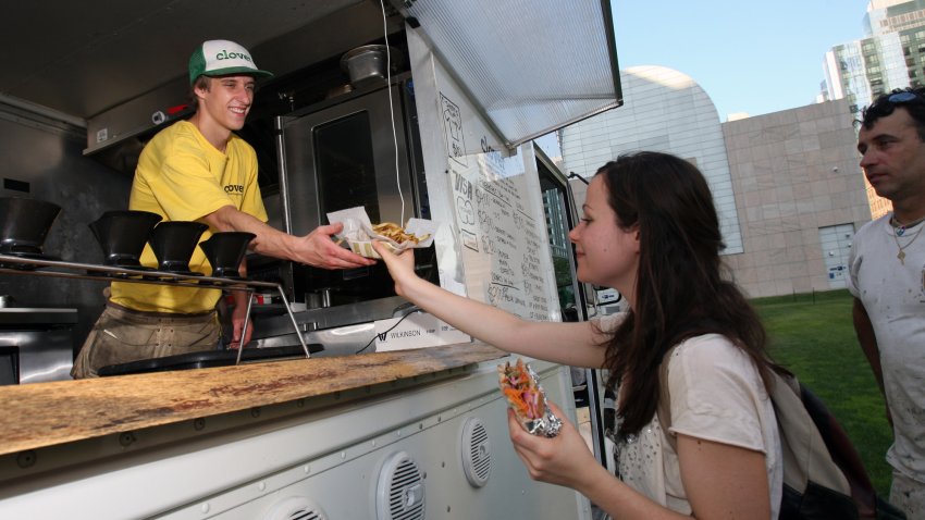 (083110 Boston, MA) Shauna Galante from Boston picks up some fries and a sandwich from Bobby Duddy working the “Clover” food truck parked in Dewey Square near South Station, August 31, 2010, Boston, MA. (Staff photo by John Wilcox) (Photo by John Wilcox/MediaNews Group/Boston Herald via Getty Images)