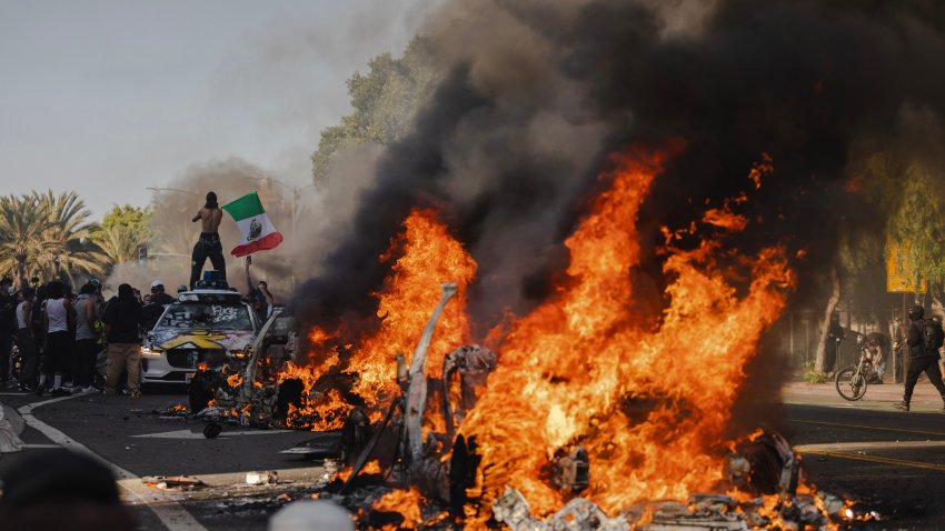 LOS ANGELES, CALIFORNIA – JUNE 8: Several cars burn on North Los Angeles street during clashes between protesters and police on June 8, 2025 in Downtown Los Angeles, California. The clashes come after ICE raids swept throughout the city over the weekend. (Photo by Jim Vondruska/Getty Images)