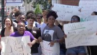 High school students in Woburn hold signs protesting teacher layoffs.