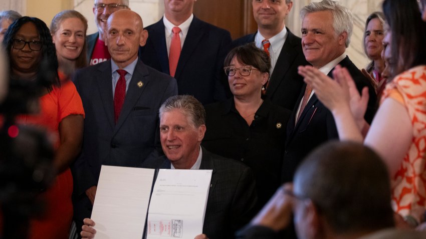 Rhode Island Gov. Dan McKee presents a signed bill that bans the sale of assault-style weapons in the state of Rhode Island at the Rhode Island Statehouse in Providence on Thursday, June 26, 2025.