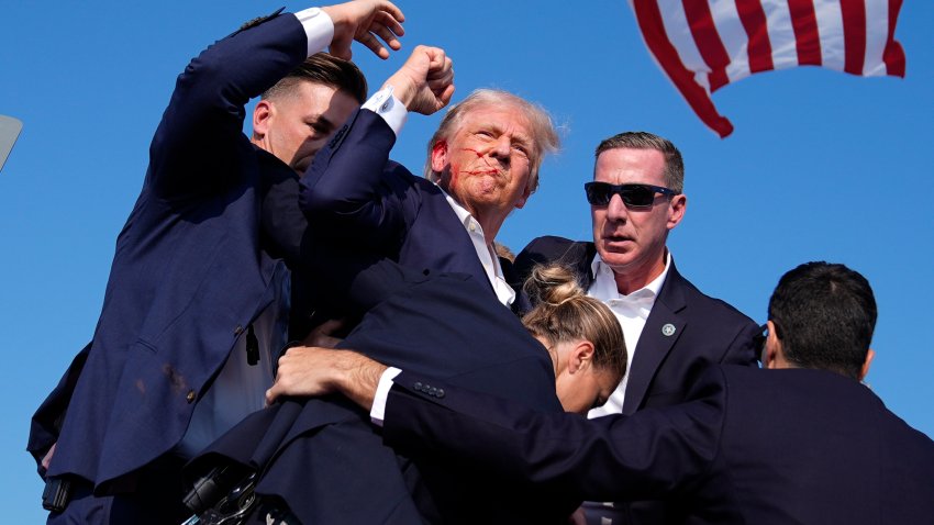 Republican presidential candidate former President Donald Trump is surrounded by U.S. Secret Service agents at a campaign rally, July 13, 2024, in Butler, Pa.