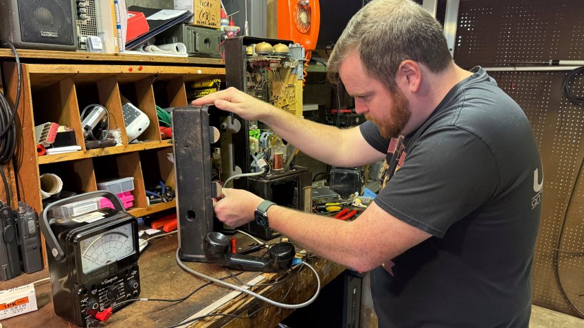 Patrick Schlott repairs an old payphone in his basement workshop on July 16, 2025, in Williamstown, Vt.
