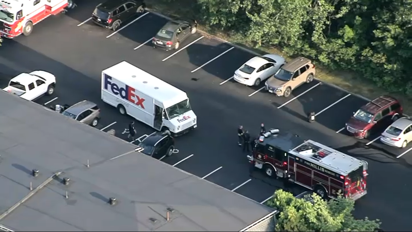 A fire truck facing a FedEx delivery truck at a Millis, Massachusetts, apartment complex during a hazmat response for what turned out to be industrial cleaner on Thursday, July 24, 2025.