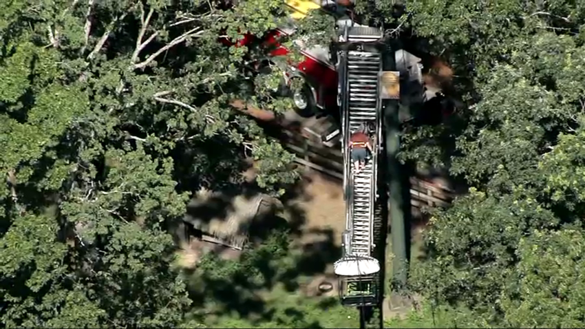 A person walking down a ladder from a Southwick Zoo Skyfari gondola car on Monday, July 21, 2025.