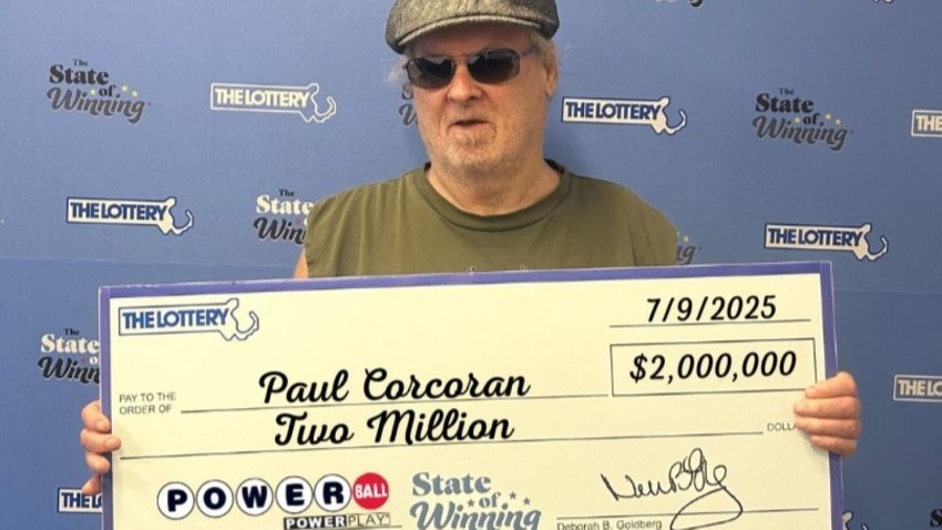 Paul Corcoran holds a check for $2 million from the Massachusetts Lottery after winning a Powerball game with two separate tickets.