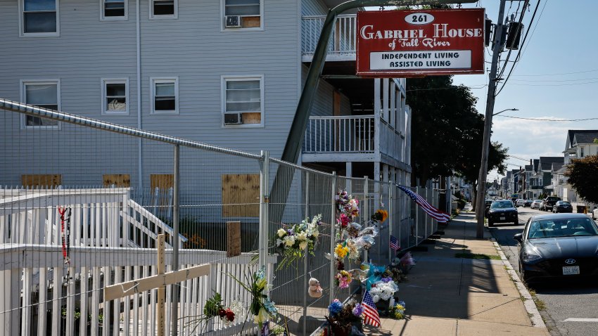 Fall River, MA – July 23: Flowers, photographs and memorial items are placed along the chain-link fence surrounding Gabriel House assisted living facility on July 23, 2025. (Photo by Erin Clark/The Boston Globe via Getty Images)
