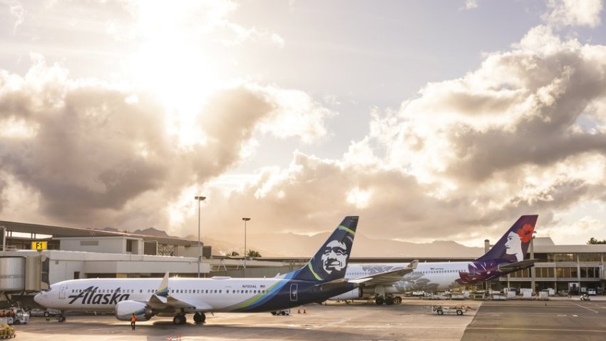 Alaska Airlines and Hawaiian Airlines aircrafts side by side at Daniel K. Inouye International Airport in Honolulu.