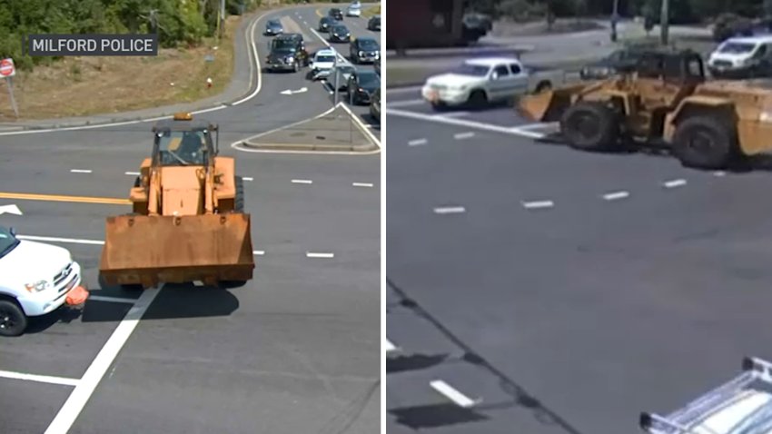 Surveillance footage shows a bucket loader nearly collide with a pickup truck at an intersection in Milford, Massachusetts, on Friday, Aug. 15, 2025.