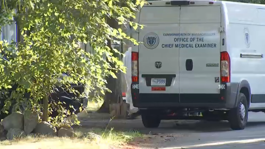 An Office of the Chief Medical Examiner van outside a Raynham, Massachusetts, home where two adults were found fatally shot on Friday, Aug. 8, 2025.
