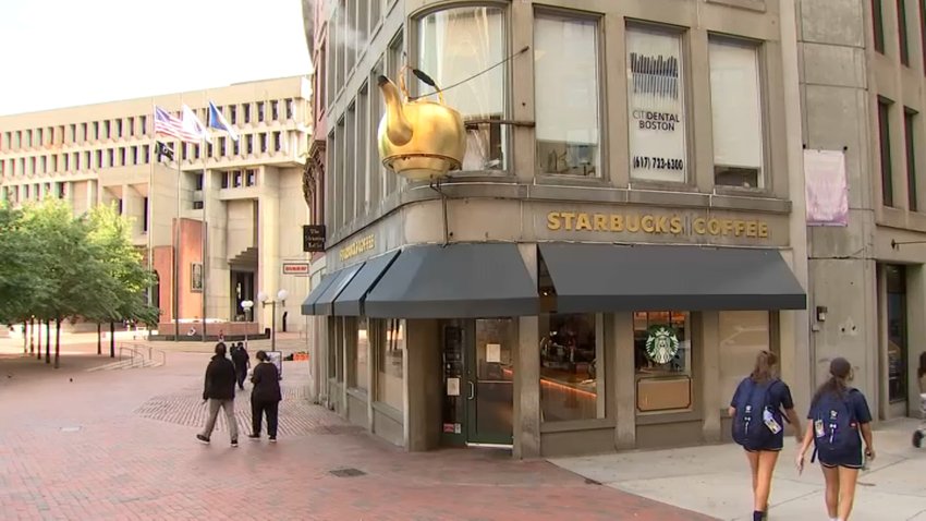 A Starbucks Coffee located in Boston's Government Square, featuring a steaming kettle above the door.