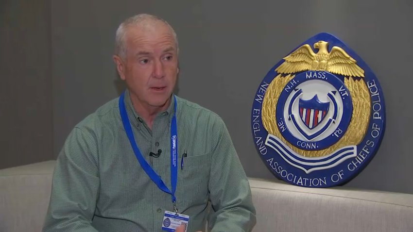 Former Yarmouth, Mass., Police Chief Frank Frederickson, speaking next to a New England Association of Chiefs of Police seal.