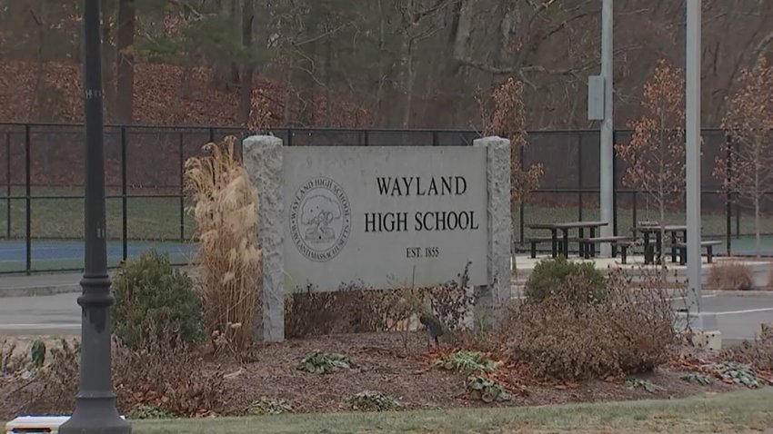 A photo of a stone sign that reads "Wayland High School"
