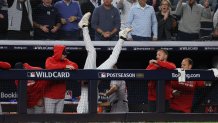 Oct 2, 2025; Bronx, New York, USA; New York Yankees third baseman Ryan McMahon (19) falls into the Boston Red Sox dugout after making a catch of a popup in the eighth inning during game three of the Wildcard round for the 2025 MLB playoffs at Yankee Stadium. Mandatory Credit: Vincent Carchietta-Imagn Images