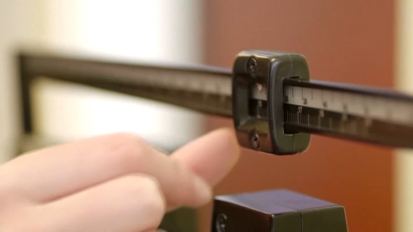 A person touching a physician scale.