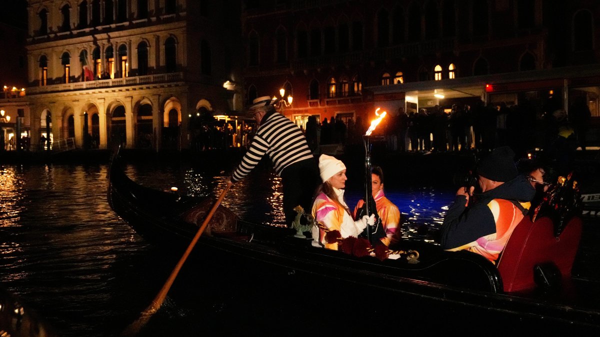 Olympic flame makes historic passage down Venice's Grand Canal