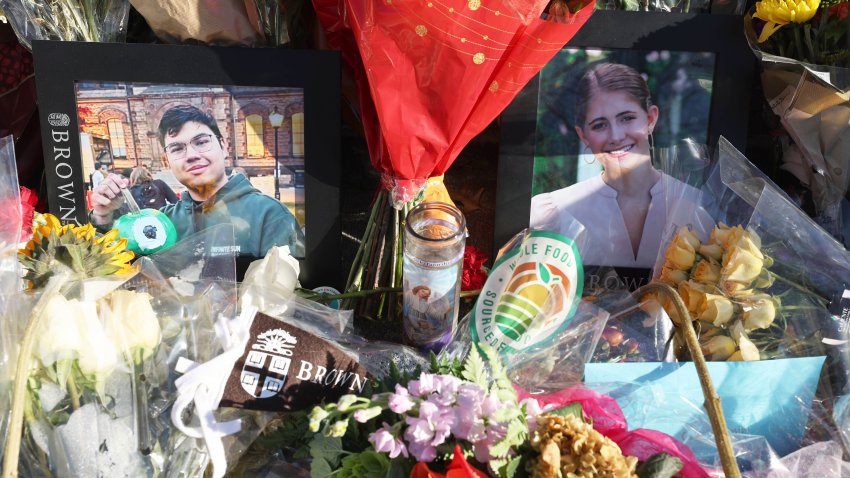 Photos of the two Brown University students killed in the Dec. 13 mass shooting, MukhammadAziz Umurzokov and Ella Cook, are displayed at a makeshift memorial on Dec. 18 outside the Barus & Holley Building, where the attack took place.