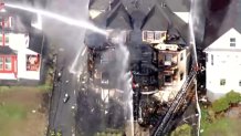 Bomberos empapando un edificio dañado por un incendio en Lowell, Massachusetts, el martes 5 de mayo de 2026.