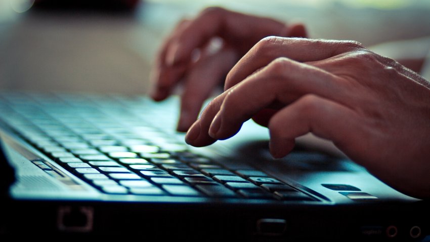 Women is writing on laptop keyboard.