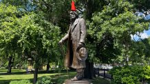 A traffic cone sits atop a statue of Edward Everett Hale in Boston.