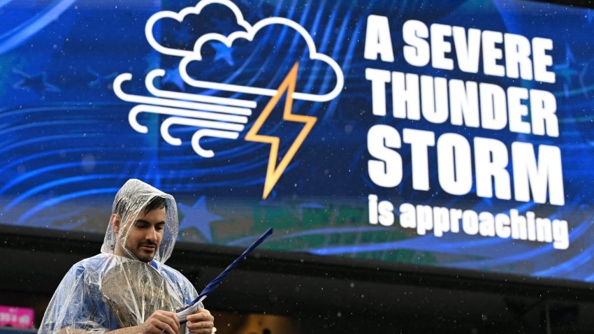 A French fan gestures past a screen showing a severe thunder storm warning.