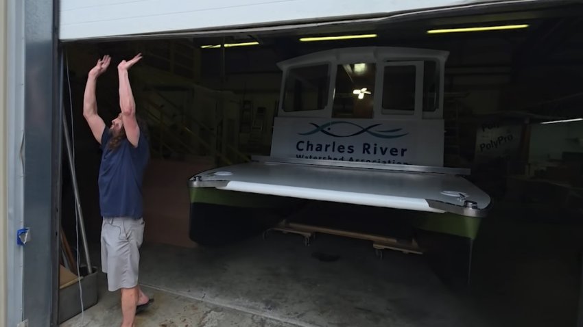 Wada Hoppah founder Drew Rollert opens a garage door to reveal the ferry boat at a Concord, Massachusetts, warehouse.
