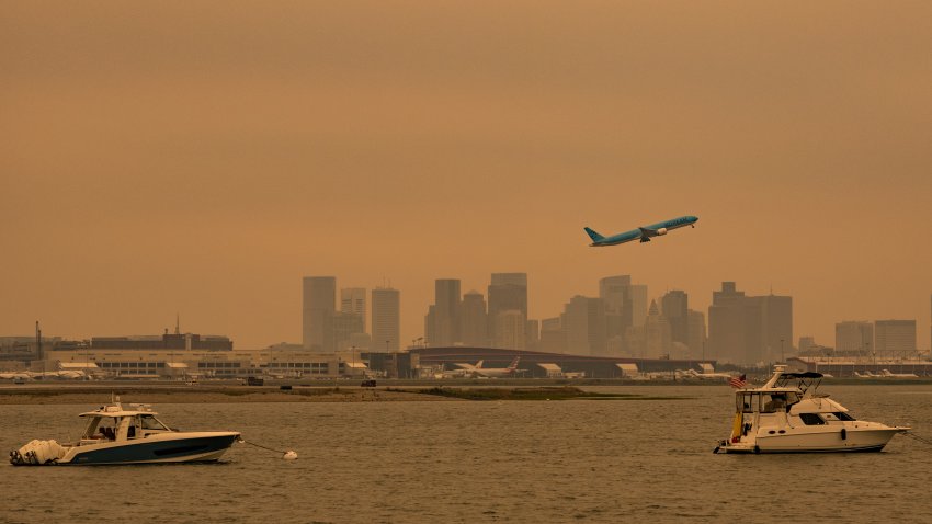 A plane taking off into the wildfire smoke-darkened sky over Boston on Wednesday, July 15, 2026.