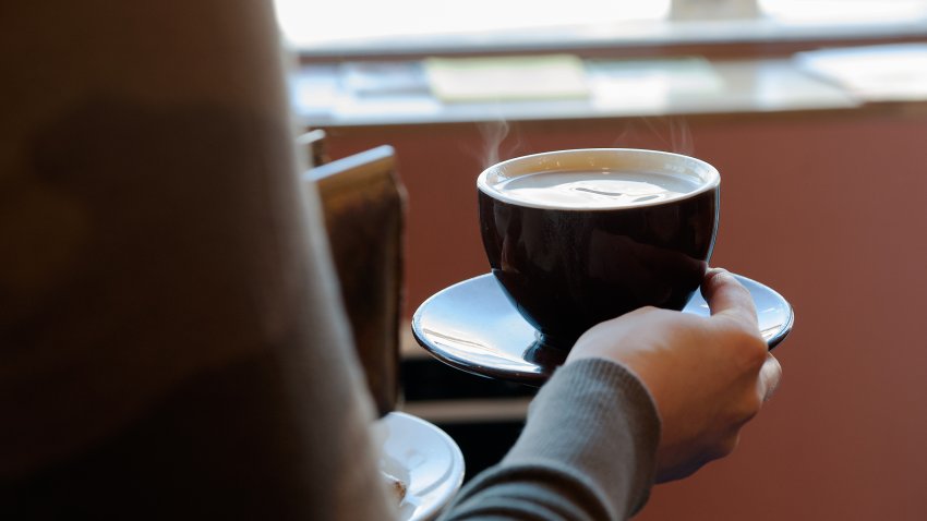 A customer carries a cup of coffee to her table at Colson Patisserie on February 22, 2016.
(Photo by Bryan Thomas/Getty Images)
