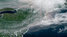 A satellite view of the Northeast U.S. on Tuesday, July 14, 2026. Wildfire smoke can be seen — a darker color mixed in with the white of the clouds.