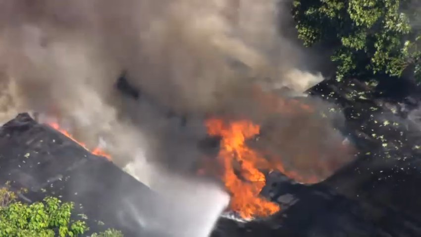 Flames rise from a large fire burning in Wakefield, Massachusetts, on Friday, Aug. 7, 2026.