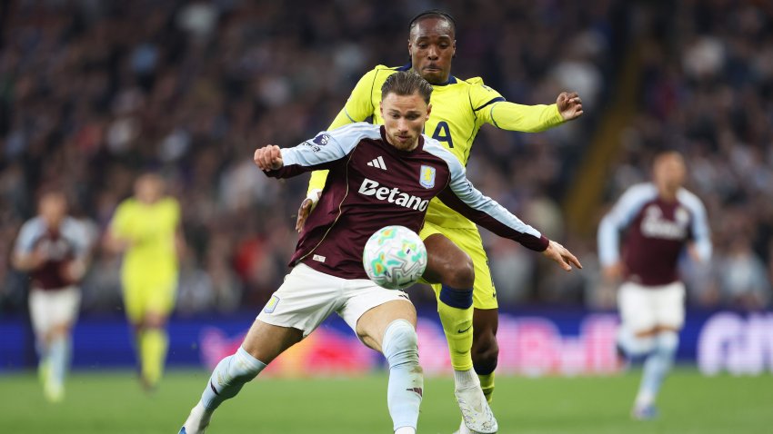 Matty Cash of Aston Villa is challenged by Mathys Tel of Tottenham.