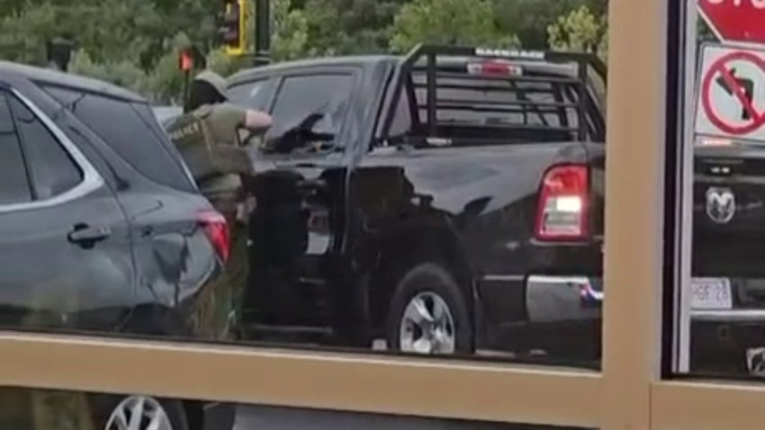 A still from video shared with Telemundo Nueva Inglaterra appearing to show an immigration enforcement agent breaking a pickup truck's window in New Bedford, Massachusetts, on Tuesday, Sept. 22, 2026.