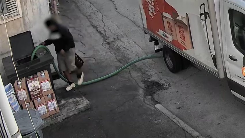 A still from surveillance video showing a person siphoning cooking oil from a Beverly, Massachusetts, restaurant into a rental truck.